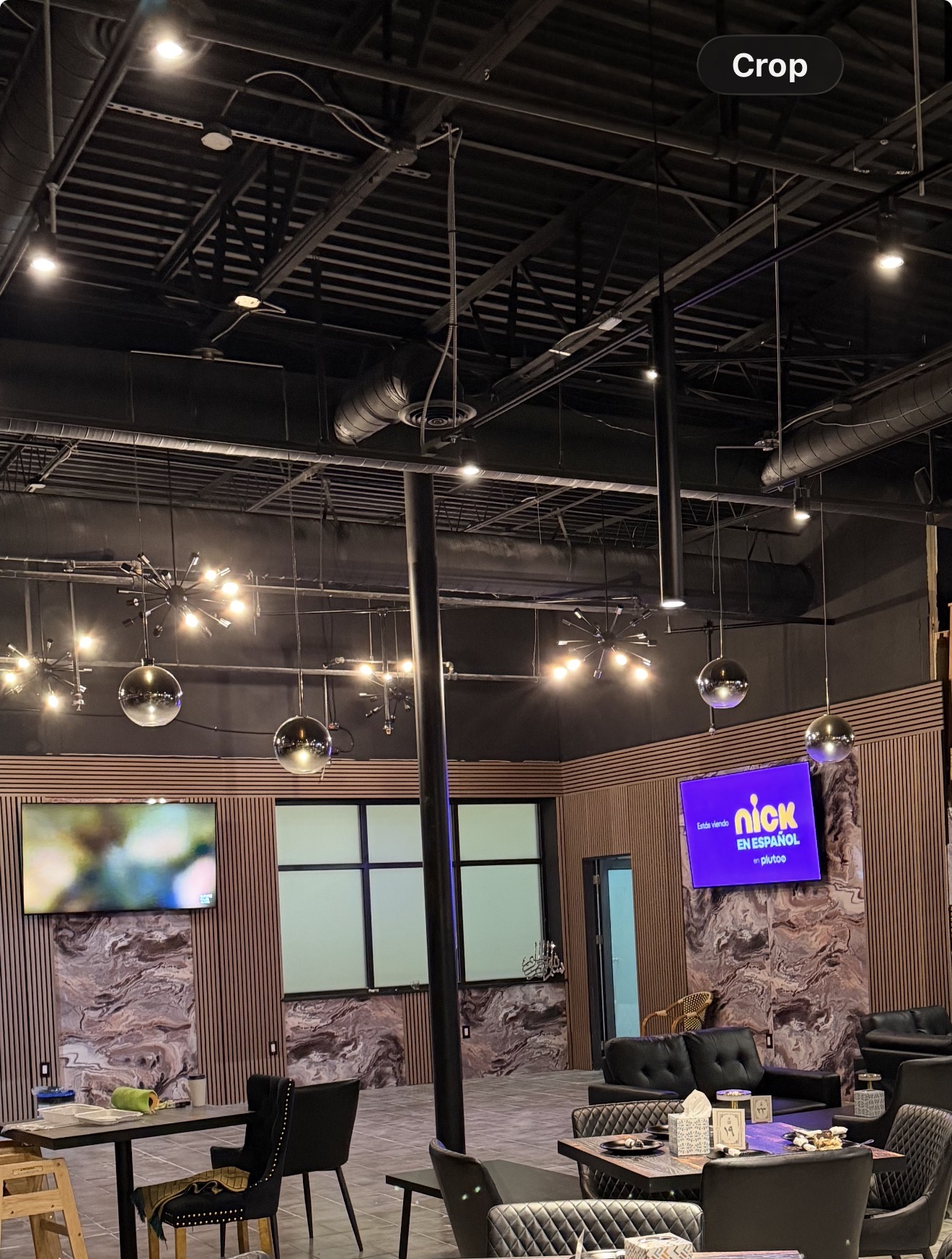 Completed commercial interior showing wall treatments, lighting, flooring, and seating